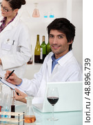 Man and woman conducting experiment on wine. Стоковое фото, агентство Ingram Publishing / Фотобанк Лори
