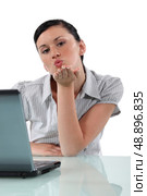 Woman at desk blowing kiss. Стоковое фото, агентство Ingram Publishing / Фотобанк Лори