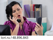 Annoyed receptionist answering ringing phones. Стоковое фото, агентство Ingram Publishing / Фотобанк Лори