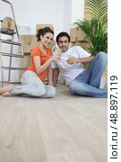 Couple sat on flooring toasting. Стоковое фото, агентство Ingram Publishing / Фотобанк Лори