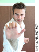 Man stood in martial art position. Стоковое фото, агентство Ingram Publishing / Фотобанк Лори