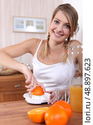 Woman squeezing orange juice. Стоковое фото, агентство Ingram Publishing / Фотобанк Лори