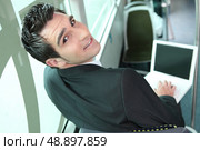 Young brown-haired man in a bus with computer. Стоковое фото, агентство Ingram Publishing / Фотобанк Лори