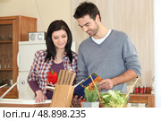 Young couple looking at a recipe book. Стоковое фото, агентство Ingram Publishing / Фотобанк Лори