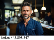 Lone man, dressed in a striking blue shirt, sits contemplatively at a dimly lit bar, immersed in his own thoughts. Стоковое AI-изображение, AI-художник Данила Большаков / Фотобанк Лори