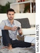 Man playing on console. Стоковое фото, агентство Ingram Publishing / Фотобанк Лори