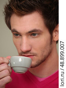 A serious man drinking a cup of coffee. Стоковое фото, агентство Ingram Publishing / Фотобанк Лори