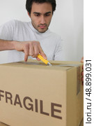 Man unpacking a cardboard box. Стоковое фото, агентство Ingram Publishing / Фотобанк Лори