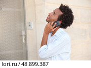 a man at phone in front of a closed door. Стоковое фото, агентство Ingram Publishing / Фотобанк Лори