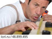 Man measuring piece wood. Стоковое фото, агентство Ingram Publishing / Фотобанк Лори