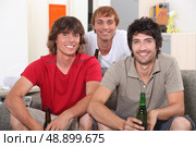 Flatmates enjoying a beer together. Стоковое фото, агентство Ingram Publishing / Фотобанк Лори