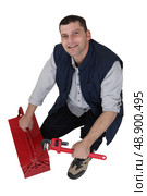 Plumber kneeling next to tool kit. Стоковое фото, агентство Ingram Publishing / Фотобанк Лори