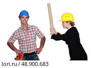 Engineer hitting a construction worker over the head. Стоковое фото, агентство Ingram Publishing / Фотобанк Лори