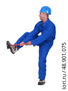 Tradesman unblocking a stoppage using a plunger. Стоковое фото, агентство Ingram Publishing / Фотобанк Лори