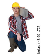 Mason resting breeze block on shoulder. Стоковое фото, агентство Ingram Publishing / Фотобанк Лори