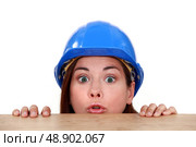 Builder peering over a ledge. Стоковое фото, агентство Ingram Publishing / Фотобанк Лори
