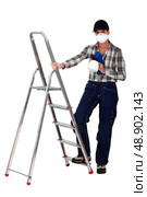 Tradesperson holding a spray gun and standing next to a stepladder. Стоковое фото, агентство Ingram Publishing / Фотобанк Лори
