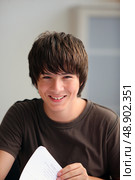 Teenage boy turning a page. Стоковое фото, агентство Ingram Publishing / Фотобанк Лори
