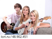 Three teenager playing musical instruments. Стоковое фото, агентство Ingram Publishing / Фотобанк Лори