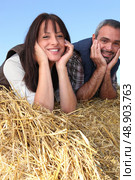 couple of farmers relaxing on a strawbale. Стоковое фото, агентство Ingram Publishing / Фотобанк Лори