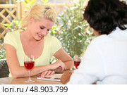Woman drinking a glass of wine and looking at a book. Стоковое фото, агентство Ingram Publishing / Фотобанк Лори