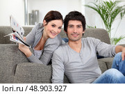 Couple relaxing in their living room. Стоковое фото, агентство Ingram Publishing / Фотобанк Лори