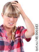 Young woman rubbing her head. Стоковое фото, агентство Ingram Publishing / Фотобанк Лори