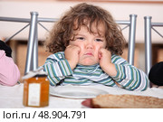 little boy grouching in front a plate of crepes. Стоковое фото, агентство Ingram Publishing / Фотобанк Лори