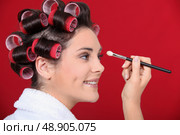 Woman with hair curlers applying make-up. Стоковое фото, агентство Ingram Publishing / Фотобанк Лори