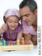 Little girl playing  board game. Стоковое фото, агентство Ingram Publishing / Фотобанк Лори