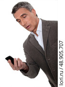Surprised man looking at telephone. Стоковое фото, агентство Ingram Publishing / Фотобанк Лори