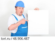 Surprised tradesman holding a blank sign. Стоковое фото, агентство Ingram Publishing / Фотобанк Лори