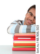 Smiling man with a stack of files. Стоковое фото, агентство Ingram Publishing / Фотобанк Лори