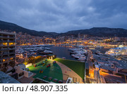 Monaco, Monaco Ville, Monte-Carlo, 31 March 2016: In Port Hercules night falls , night lighting is switched, mega yachts, port Monaco, landmark, cityscape, evening. Редакционное фото, фотограф Vladimir Drozdin / Фотобанк Лори