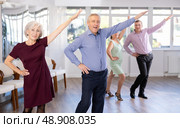 Happy senior woman and man enjoying active boogie-woogie dance in studio. Social dancing concept. Стоковое фото, фотограф Яков Филимонов / Фотобанк Лори
