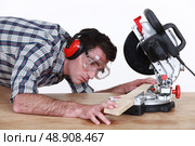 Man positioning plank of wood. Стоковое фото, агентство Ingram Publishing / Фотобанк Лори