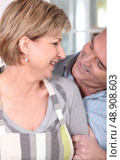 Couple in their fifties laughing in the kitchen. Стоковое фото, агентство Ingram Publishing / Фотобанк Лори
