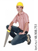 Man kneeling with saw. Стоковое фото, агентство Ingram Publishing / Фотобанк Лори