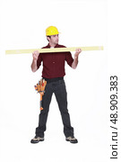 Carpenter holding a plank. Стоковое фото, агентство Ingram Publishing / Фотобанк Лори