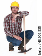 handsome bricklayer with arm resting on pickaxe. Стоковое фото, агентство Ingram Publishing / Фотобанк Лори