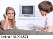Two teenagers at home listening to music. Стоковое фото, агентство Ingram Publishing / Фотобанк Лори