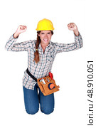 happy craftswoman kneeling and raising her hands. Стоковое фото, агентство Ingram Publishing / Фотобанк Лори