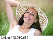 Brunette lain in field of grass. Стоковое фото, агентство Ingram Publishing / Фотобанк Лори