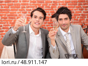 Young men in suits drinking champagne. Стоковое фото, агентство Ingram Publishing / Фотобанк Лори