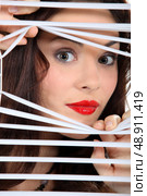 woman looking through window blinds. Стоковое фото, агентство Ingram Publishing / Фотобанк Лори