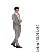 Young businessman sending text message whilst walking. Стоковое фото, агентство Ingram Publishing / Фотобанк Лори