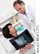 Doctor and assistant watching an x-ray. Стоковое фото, агентство Ingram Publishing / Фотобанк Лори