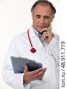 Doctor studying his patient’s results. Стоковое фото, агентство Ingram Publishing / Фотобанк Лори