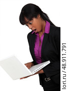 Afro-American businesswoman holding her laptop and looking very surprised. Стоковое фото, агентство Ingram Publishing / Фотобанк Лори