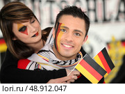 Couple supporting the German football team. Стоковое фото, агентство Ingram Publishing / Фотобанк Лори